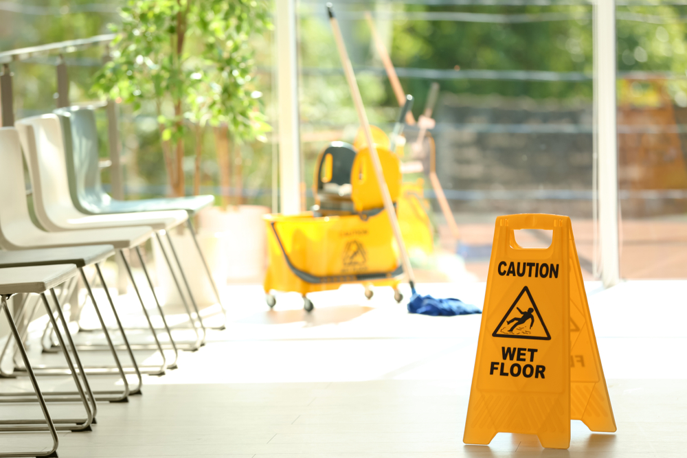 commercial cleaning mop cart, wet floor sign, and mop in workplace